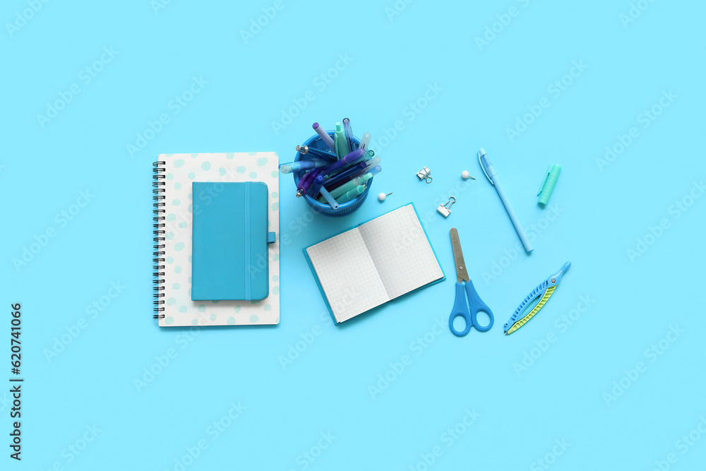 Composition with notebooks and different school stationery on blue background