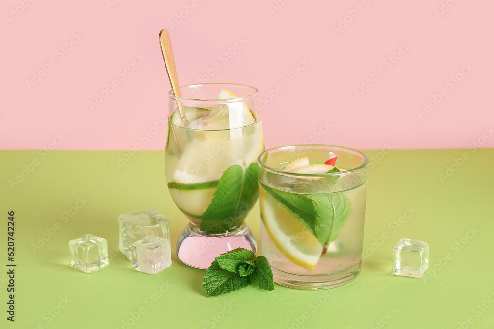 Glasses of lemonade with cucumber and mint on green table