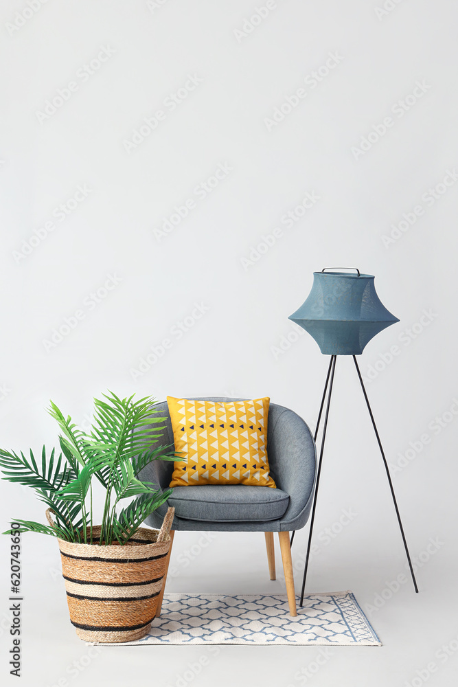 Armchair with lamp, palm tree and rug on white background