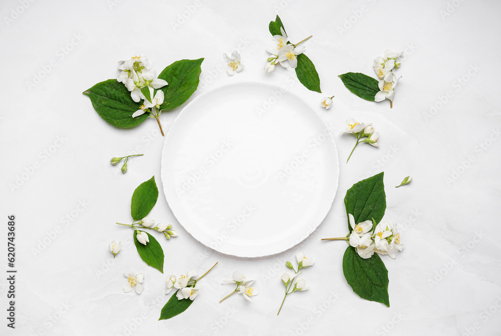 Composition with plate and beautiful jasmine flowers on light background