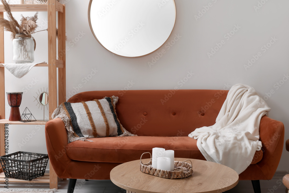 Interior of living room with brown sofa, mirror and coffee table