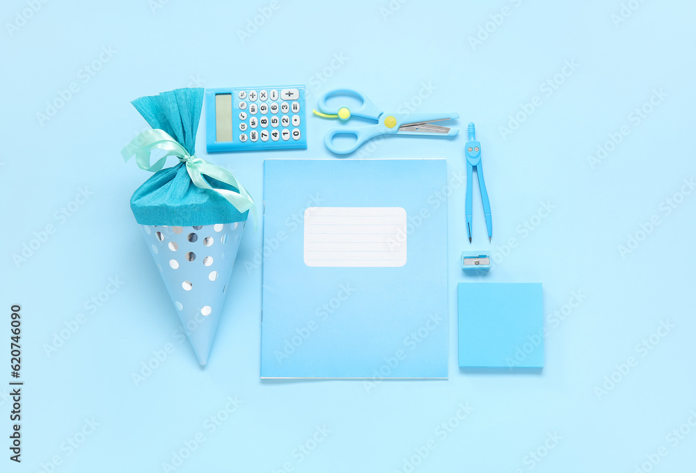 School cone with different stationery on blue background