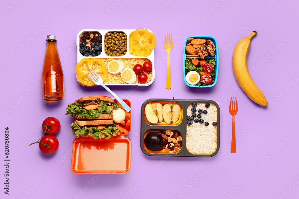 Lunchboxes with different tasty food on lilac background