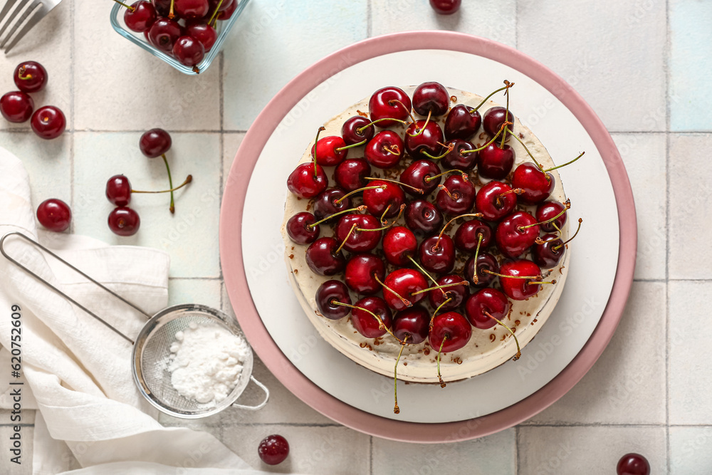 Plate with tasty cherry cake on white tile background