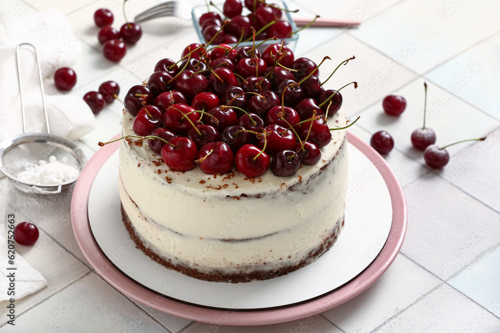 Plate with tasty cherry cake on white tile background