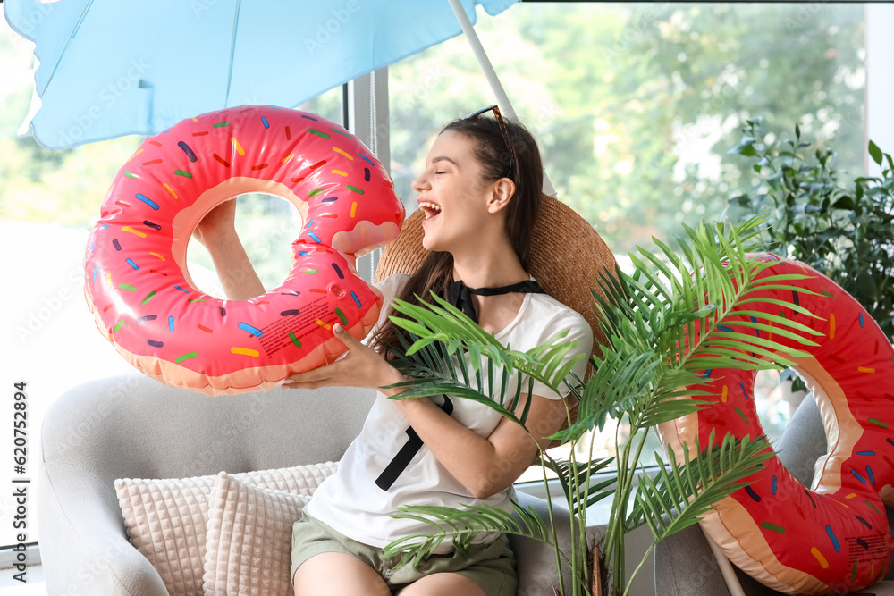 Young woman with swim ring ready for summer vacation at home