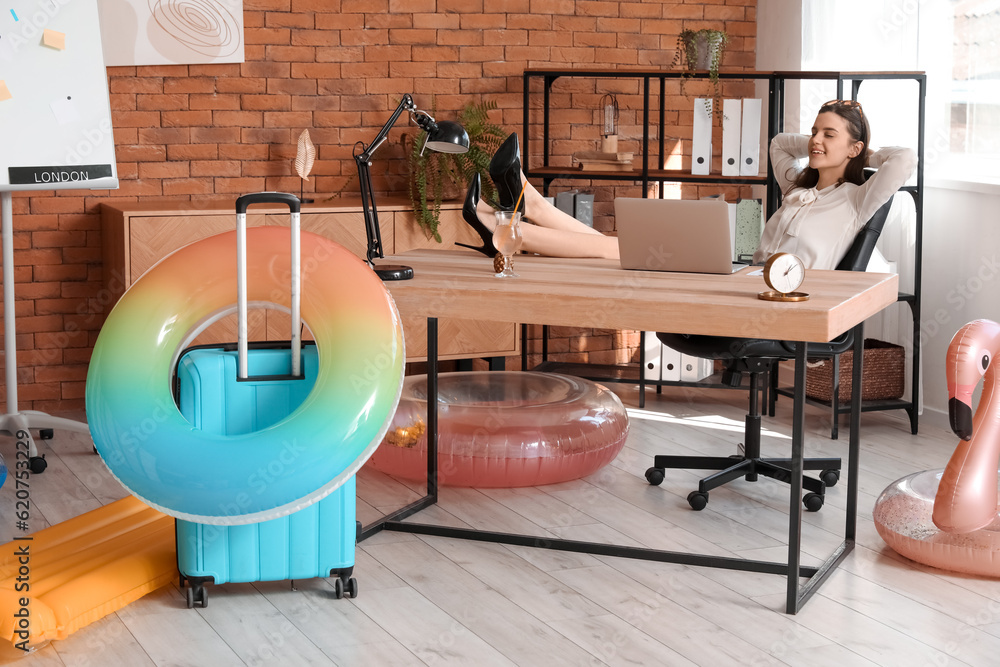 Young businesswoman ready for summer vacation in office