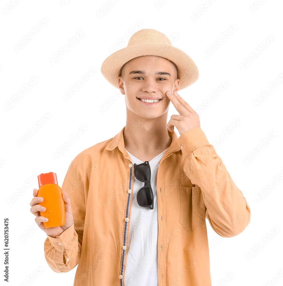 Happy young man with bottle of sunscreen cream on his face against white background