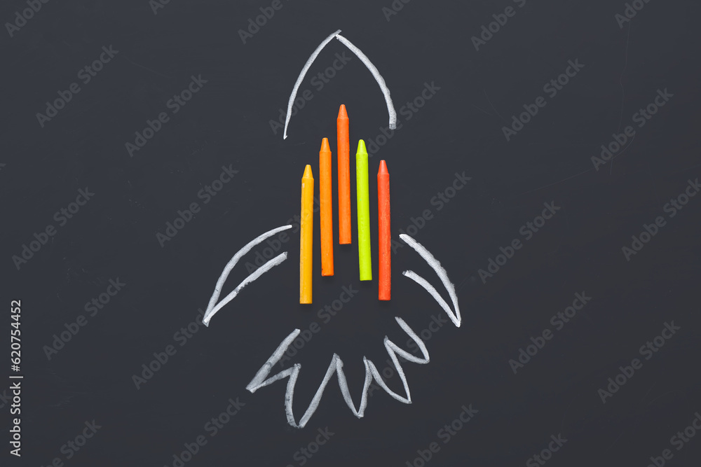 Drawn rocket with wax pencils on black background