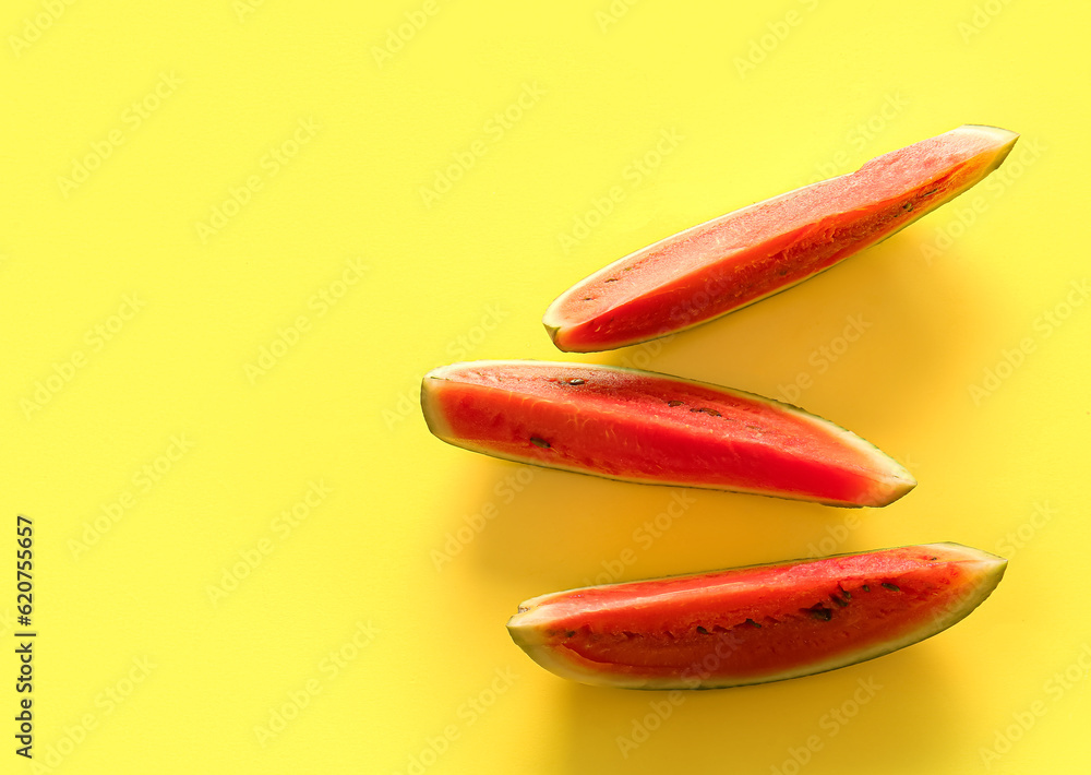 Pieces of fresh watermelon on yellow background