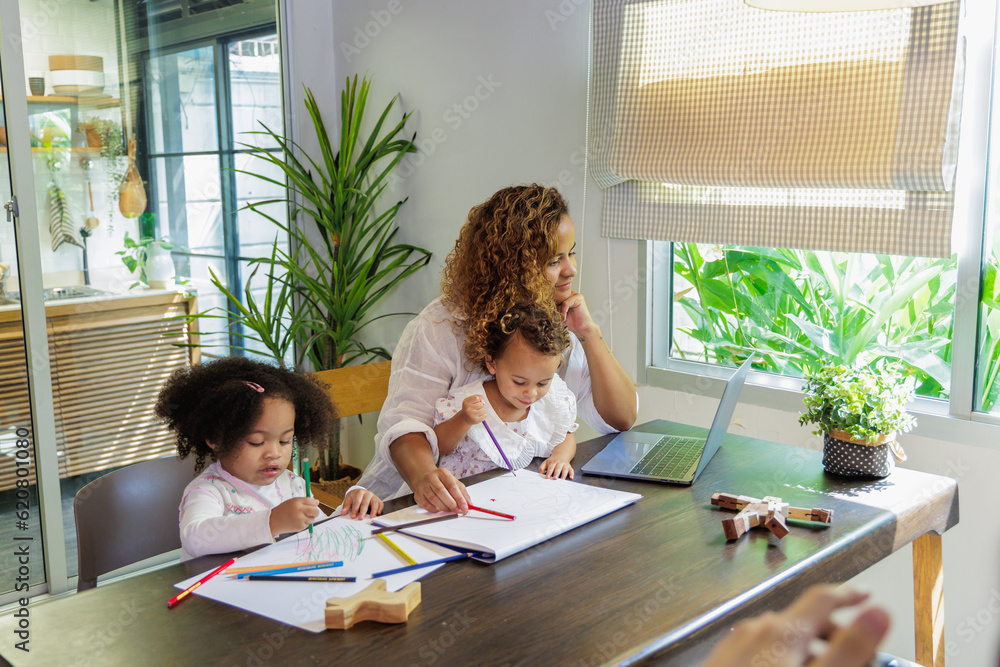 African mother multitasking painting with child while work from home