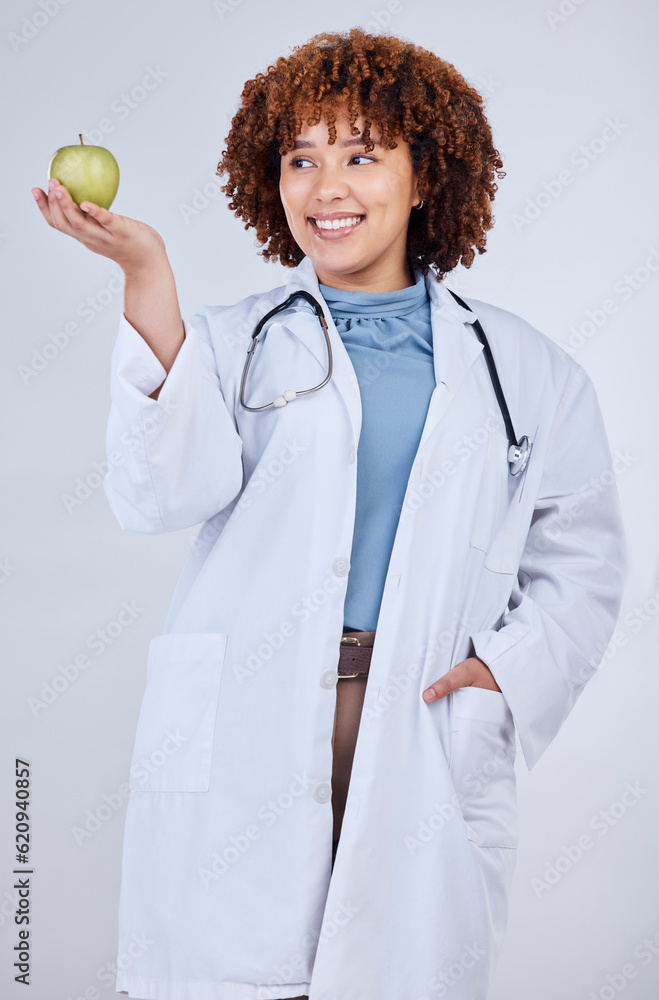 Doctor, woman and smile with apple in studio, white background and wellness. Happy medical employee,