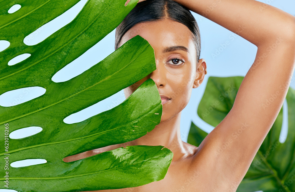 Cosmetics, leaf and portrait of a woman on a blue background for skincare, wellness and beauty glow.