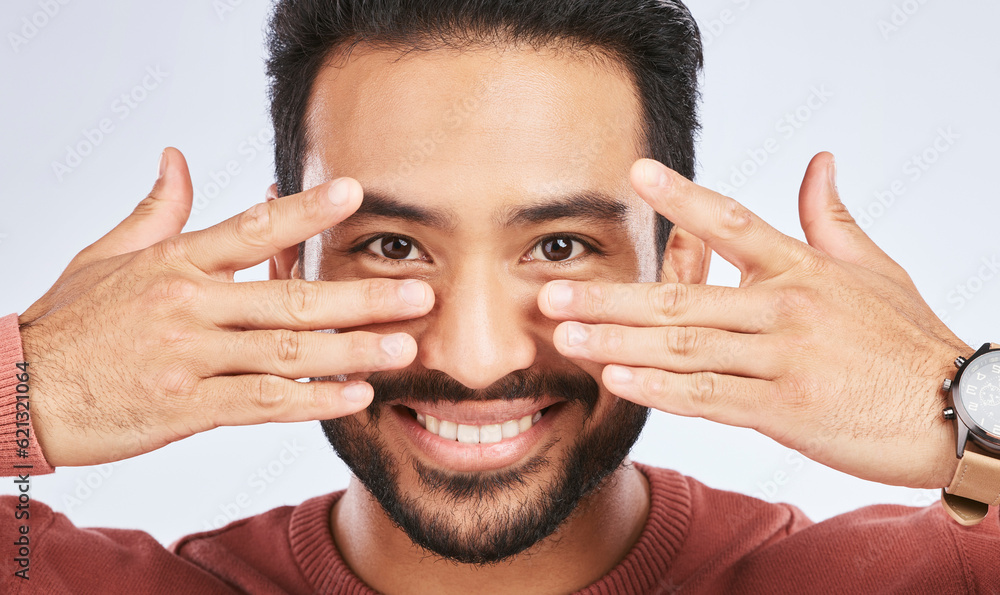 Portrait, smile and asian man with fingers on eyes in studio with confidence, personality and person