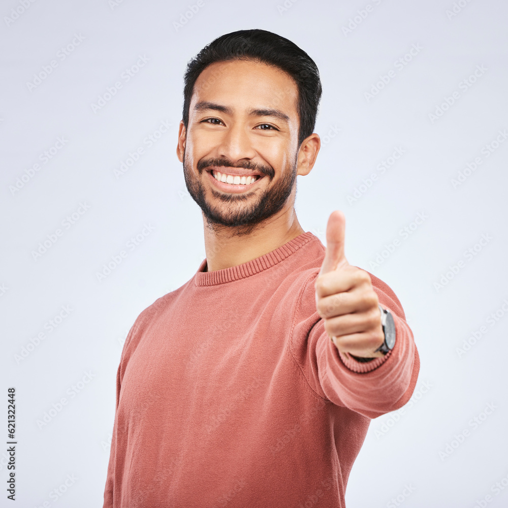 Thumbs up, portrait and happy asian man in studio, white background and thank you. Male model, thumb