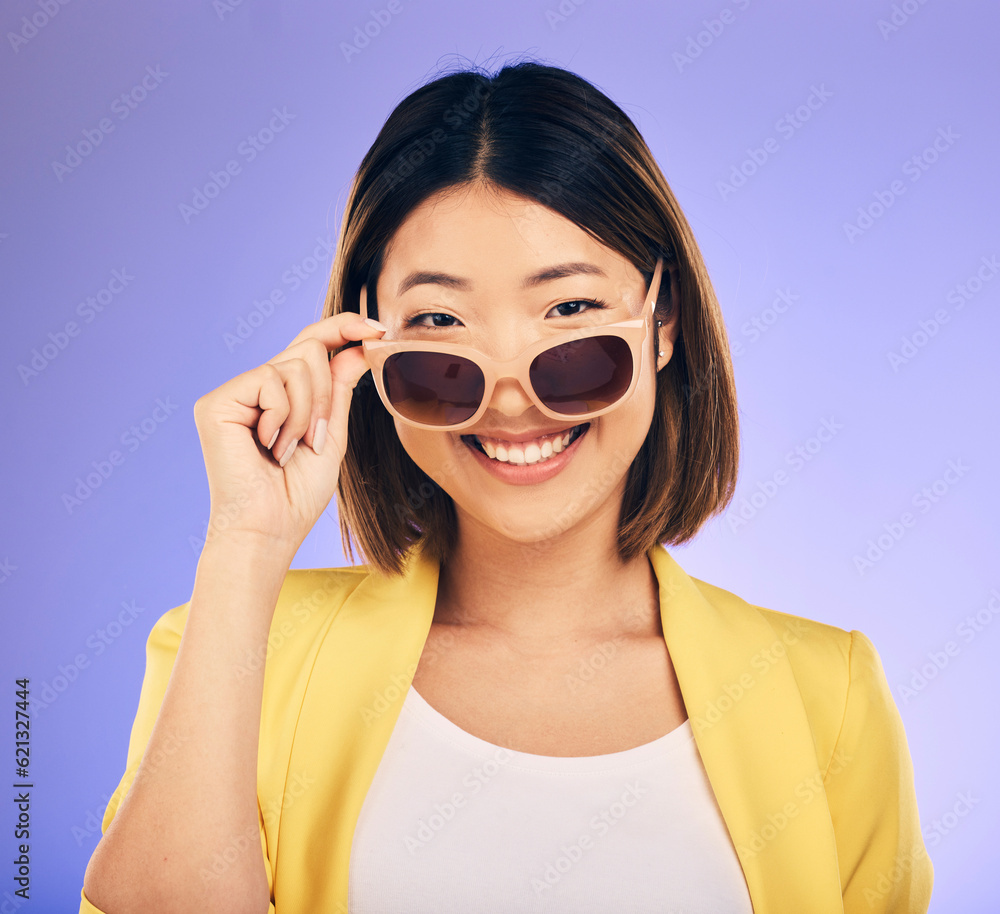 Happy asian woman, portrait and sunglasses for fashion or stylish accessory against a purple studio 