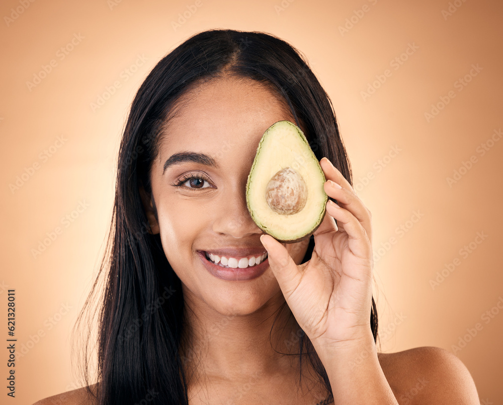 Happy, face and woman with avocado for skincare isolated on a brown background in studio. Portrait, 