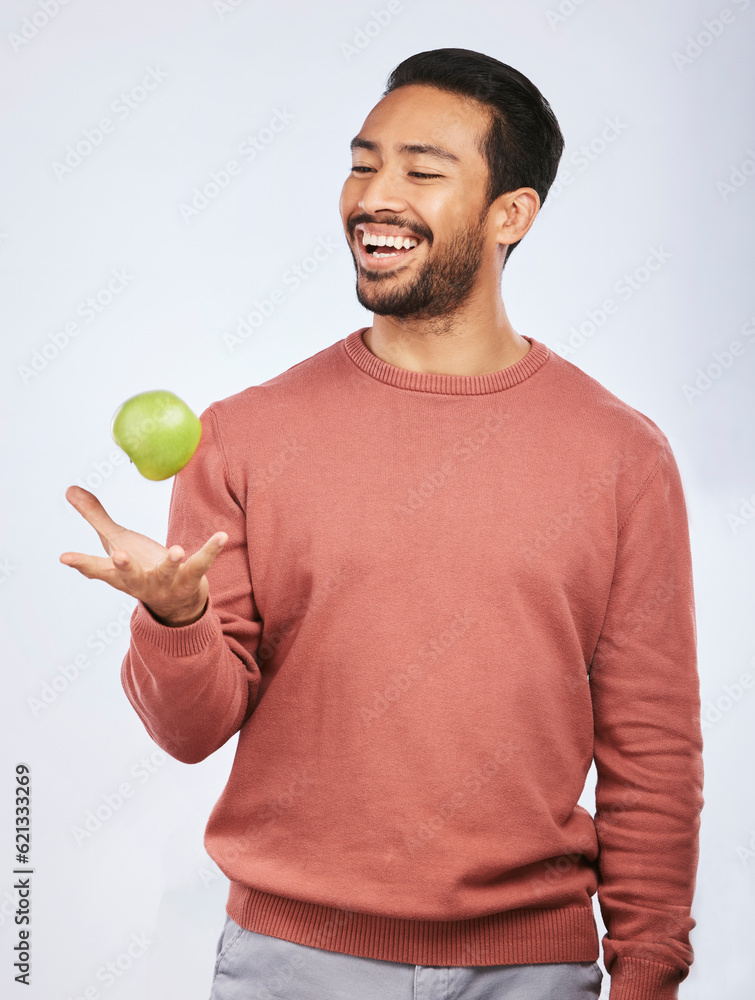 Studio, fruit throw and happy man with apple product for self care diet, clean healthy gut or nutrit