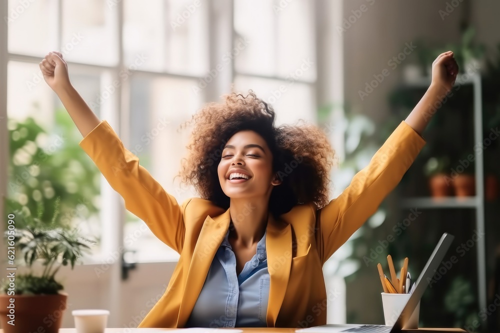 Joyful business woman freelancer entrepreneur smiling and rejoices in victory while sitting at desk 