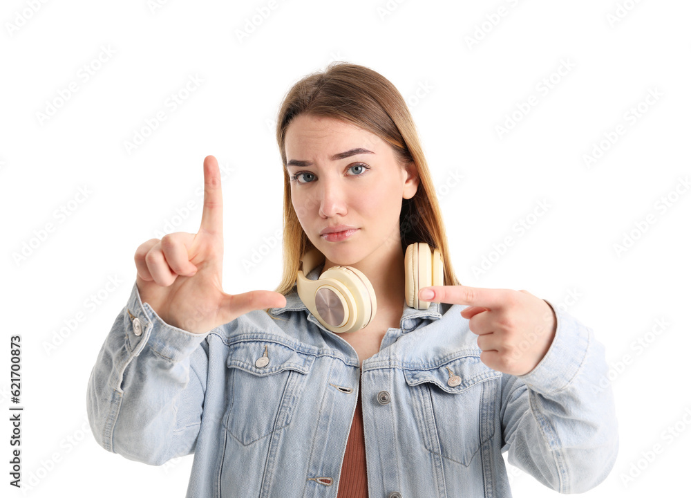 Sad young woman showing loser gesture on white background