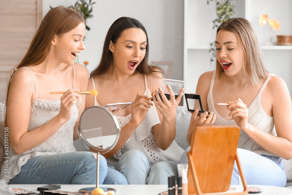 Young women doing makeup at home