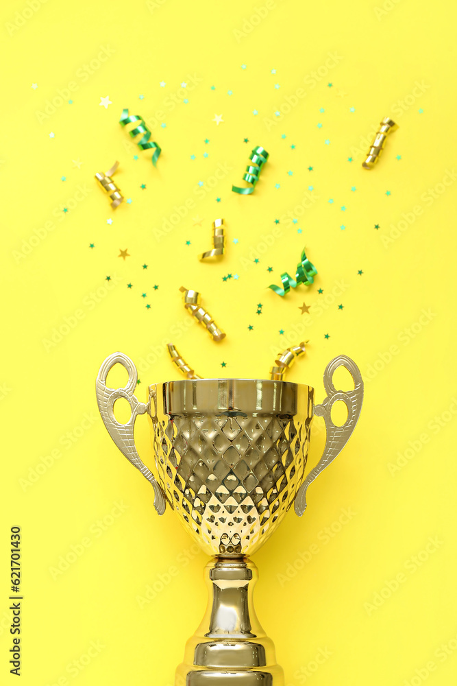 Gold cup with stars and serpentine on yellow background