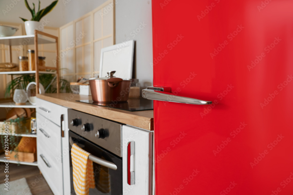 Interior of kitchen with red fridge, counters and shelving unit, closeup