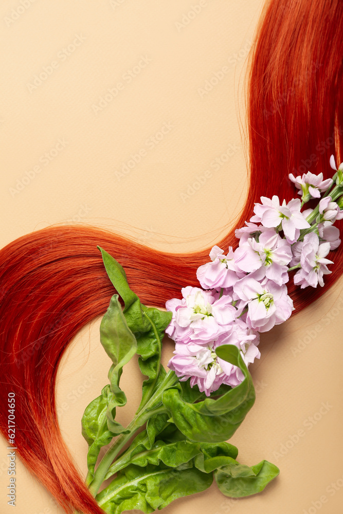 Ginger hair strand and beautiful flower on color background, closeup