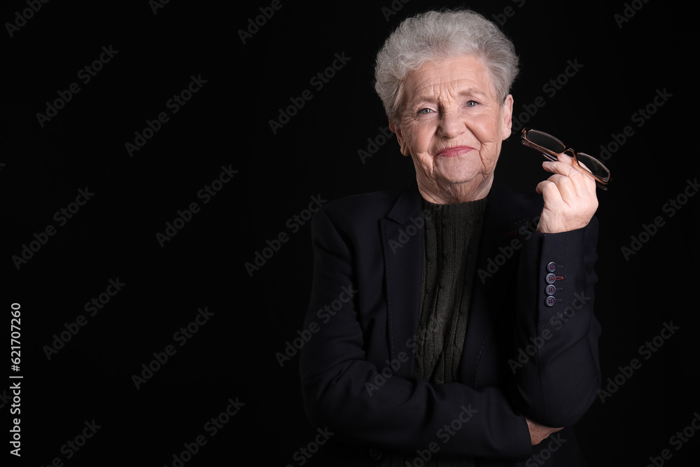 Senior woman with eyeglasses on black background