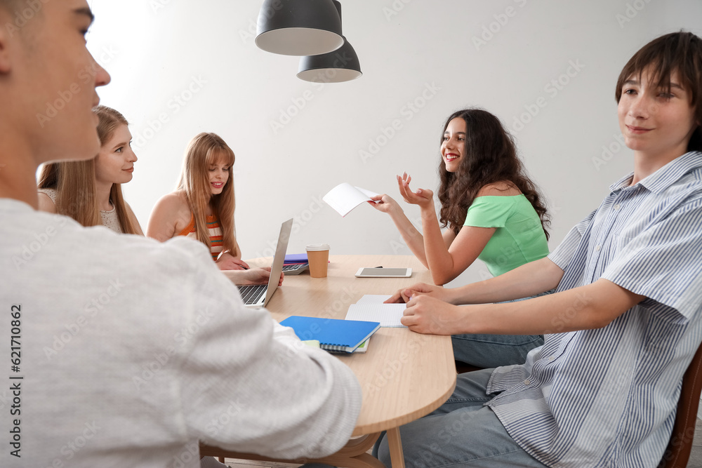 Group of students doing homework at table in room