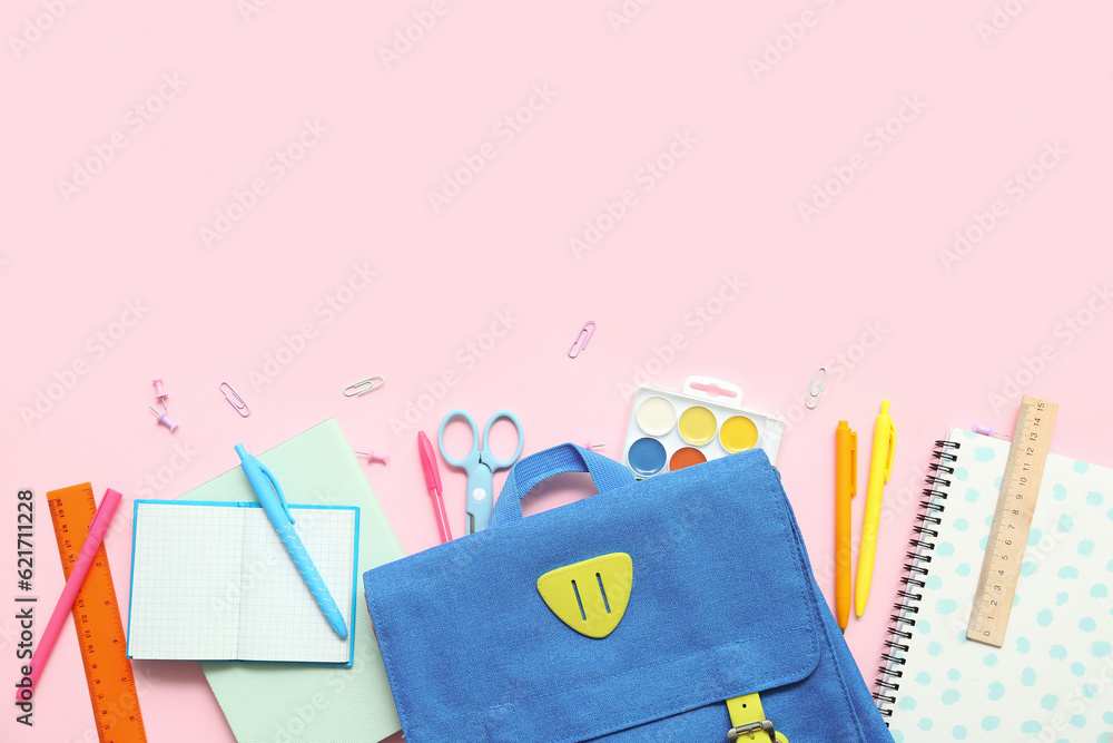 School backpack with different stationery on pink background