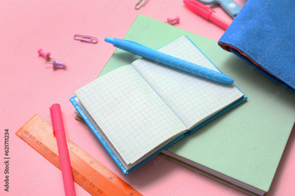 Notebooks and different school stationery on pink background, closeup