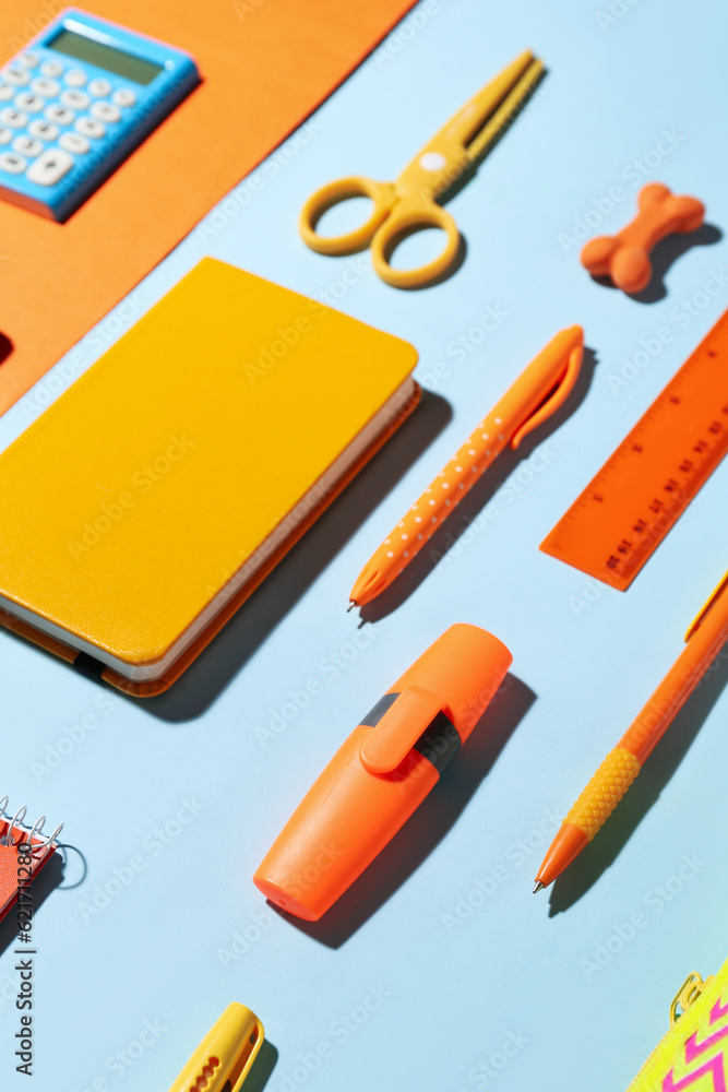 Set of notebook and different school stationery on color background, closeup