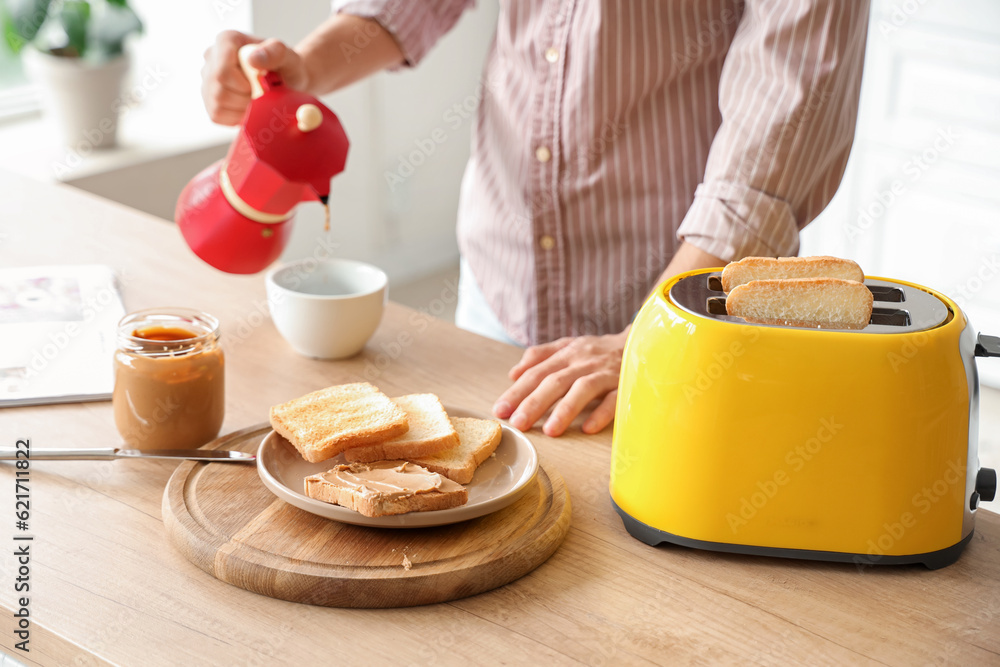 Plate of toasts with tasty nut butter in kitchen of young man