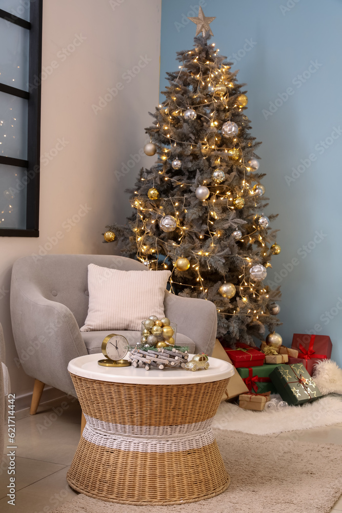 Interior of living room with Christmas tree, armchair, gift boxes and coffee table