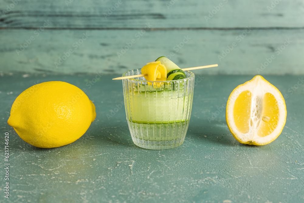 Glass of lemonade with cucumber on blue table