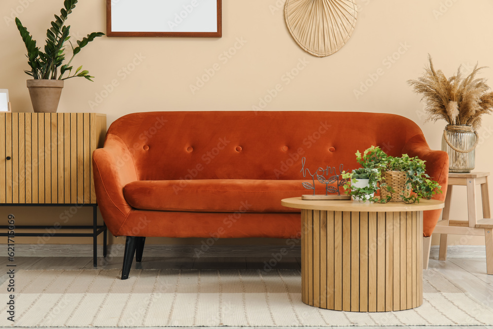 Interior of living room with cozy brown sofa, coffee table and wooden cabinet