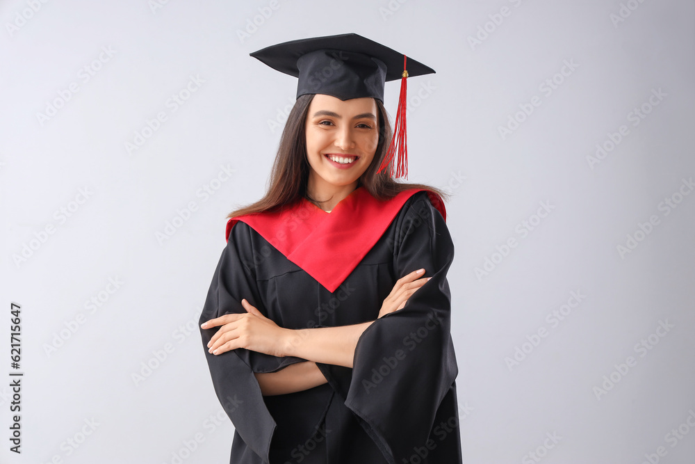 Female graduate student on light background