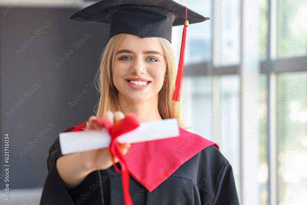 Female graduate student with diploma near window in room, closeup