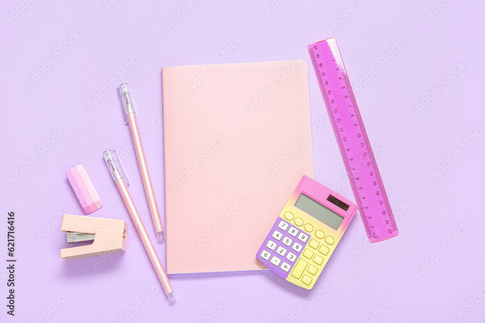 Notebook with different stationery on lilac background