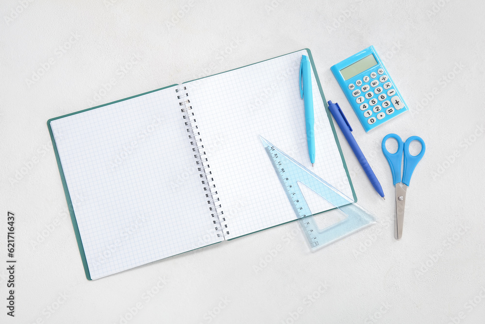 Open notebook with different stationery on white background