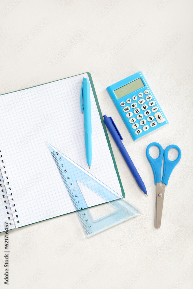 Open notebook with different stationery on white background