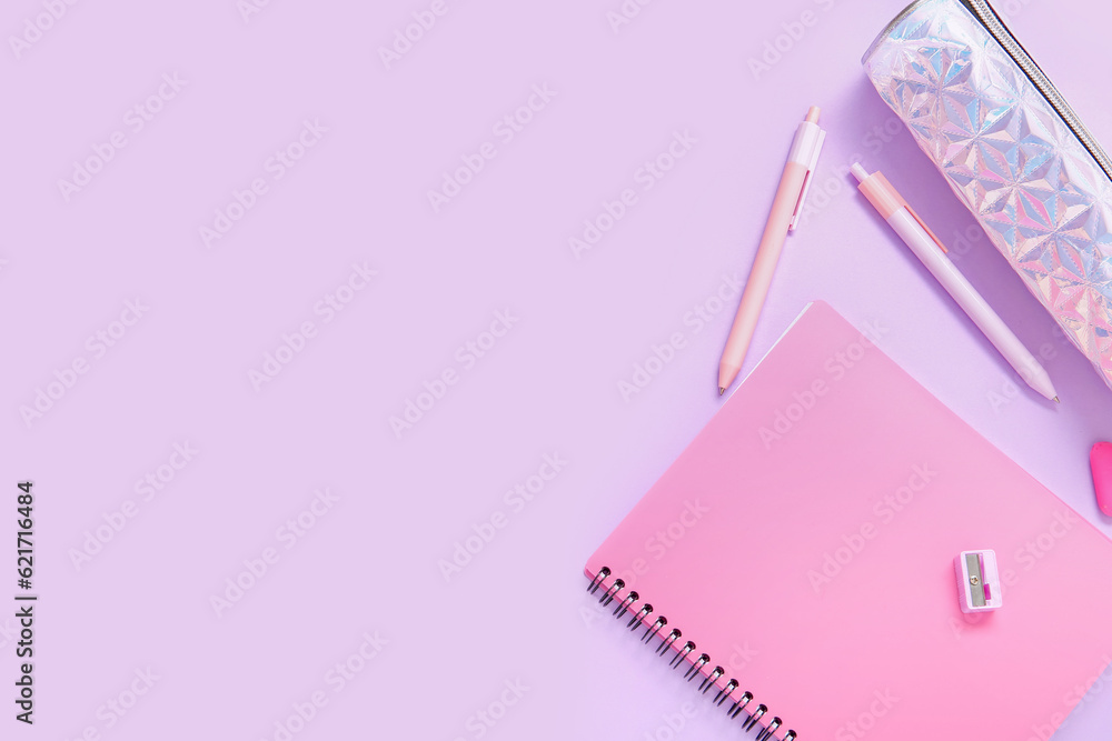 Notebook with pencil case and different stationery on lilac background