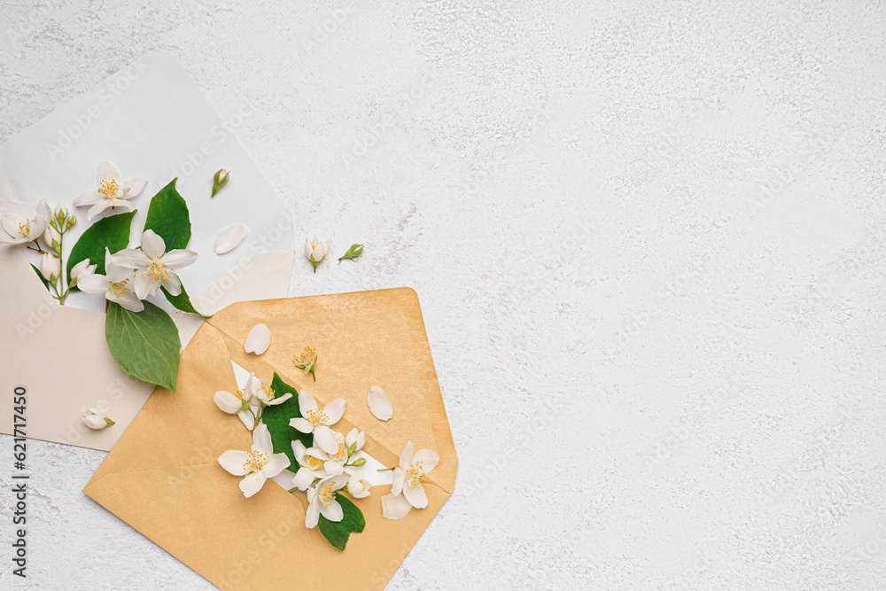 Composition with envelopes and beautiful jasmine flowers on light background