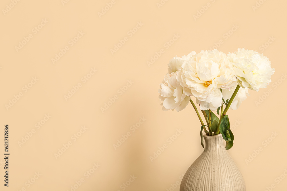 Vase of white peonies on beige background