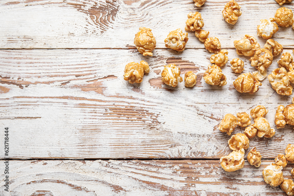 Tasty popcorn on white wooden background