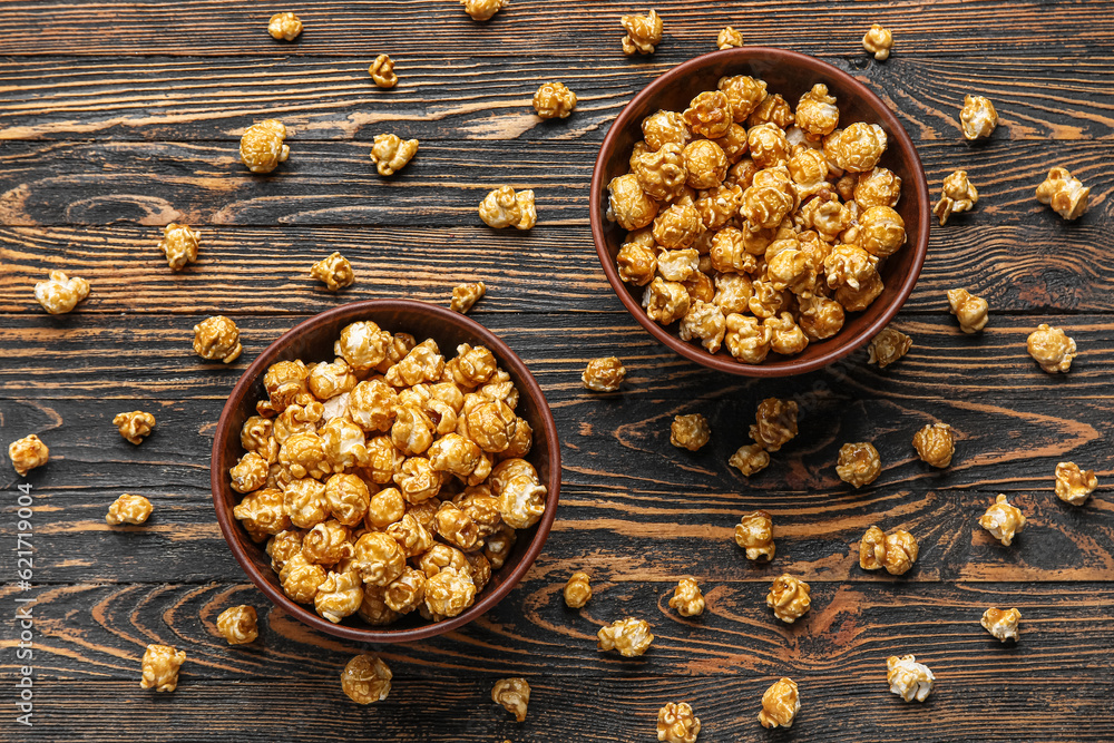 Bowls with tasty popcorn on wooden background