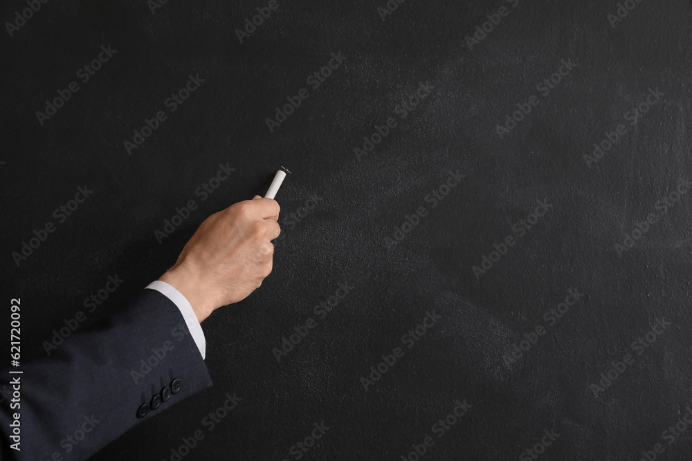 Male teacher writing on blackboard, closeup