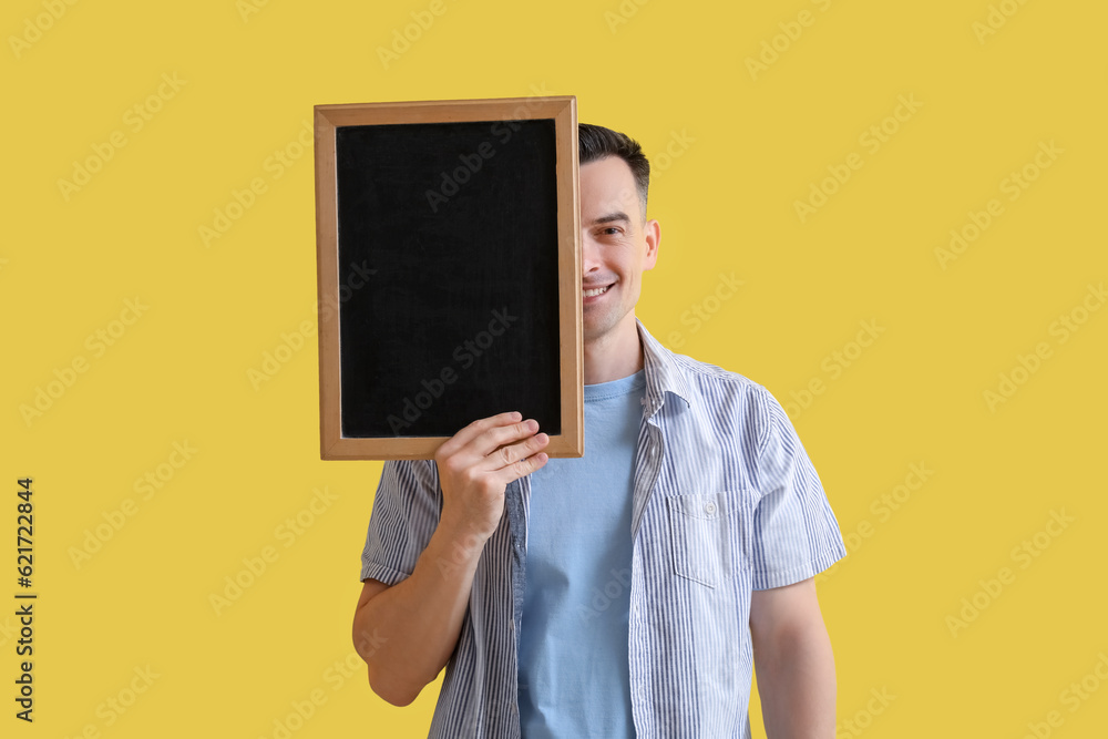 Male teacher with chalkboard on yellow background