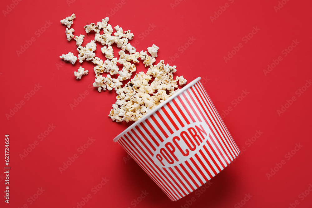 Bucket with tasty popcorn on red background